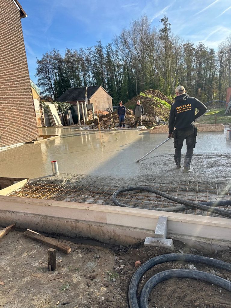 Bediener van Betonpompenspecialist stort beton met de pompslang