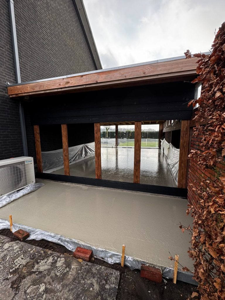 Betonvloer gestort in een aanbouw met houten kozijnen