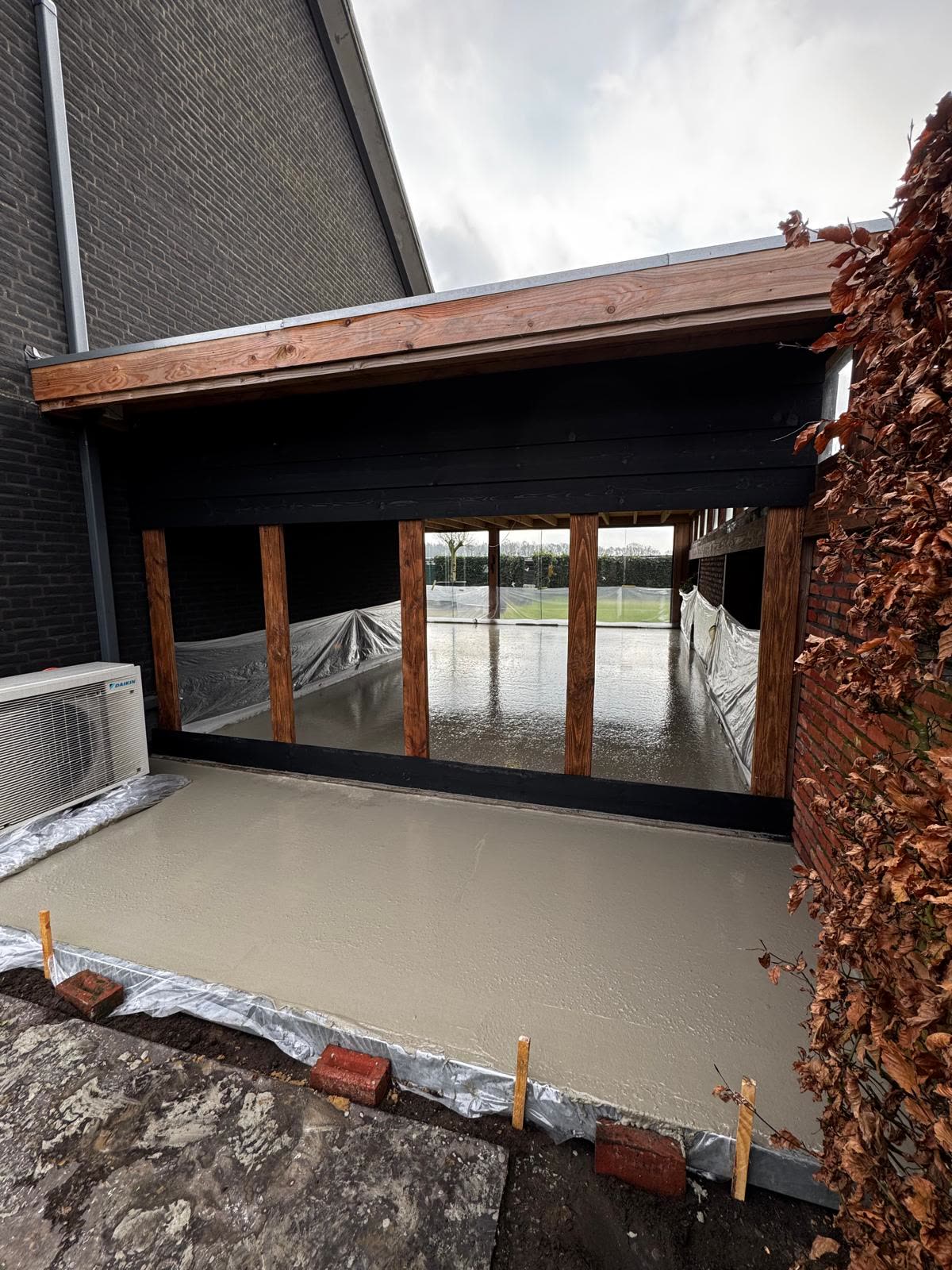 Betonvloer gestort in een aanbouw met houten kozijnen