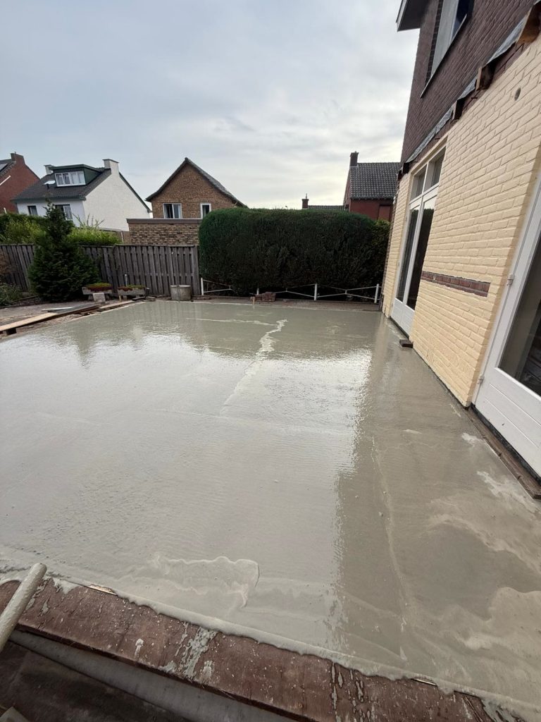 Gestorte betonvloer in de tuin naast een woning
