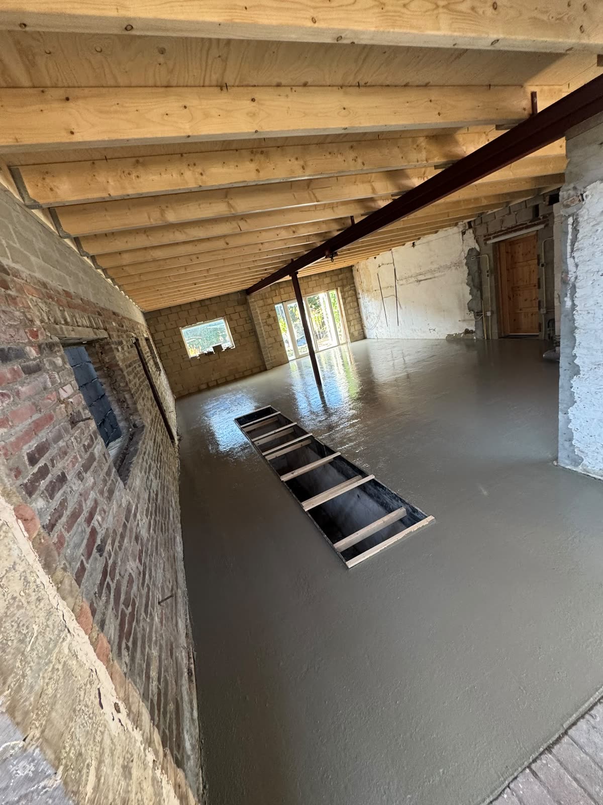 Betonvloer gestort in een verbouwde woning met houten plafond