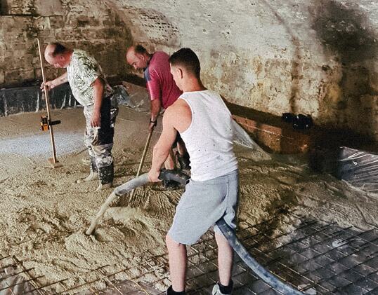 Team van Betonpompenspecialist stort een keldervloer met de betonpompslang